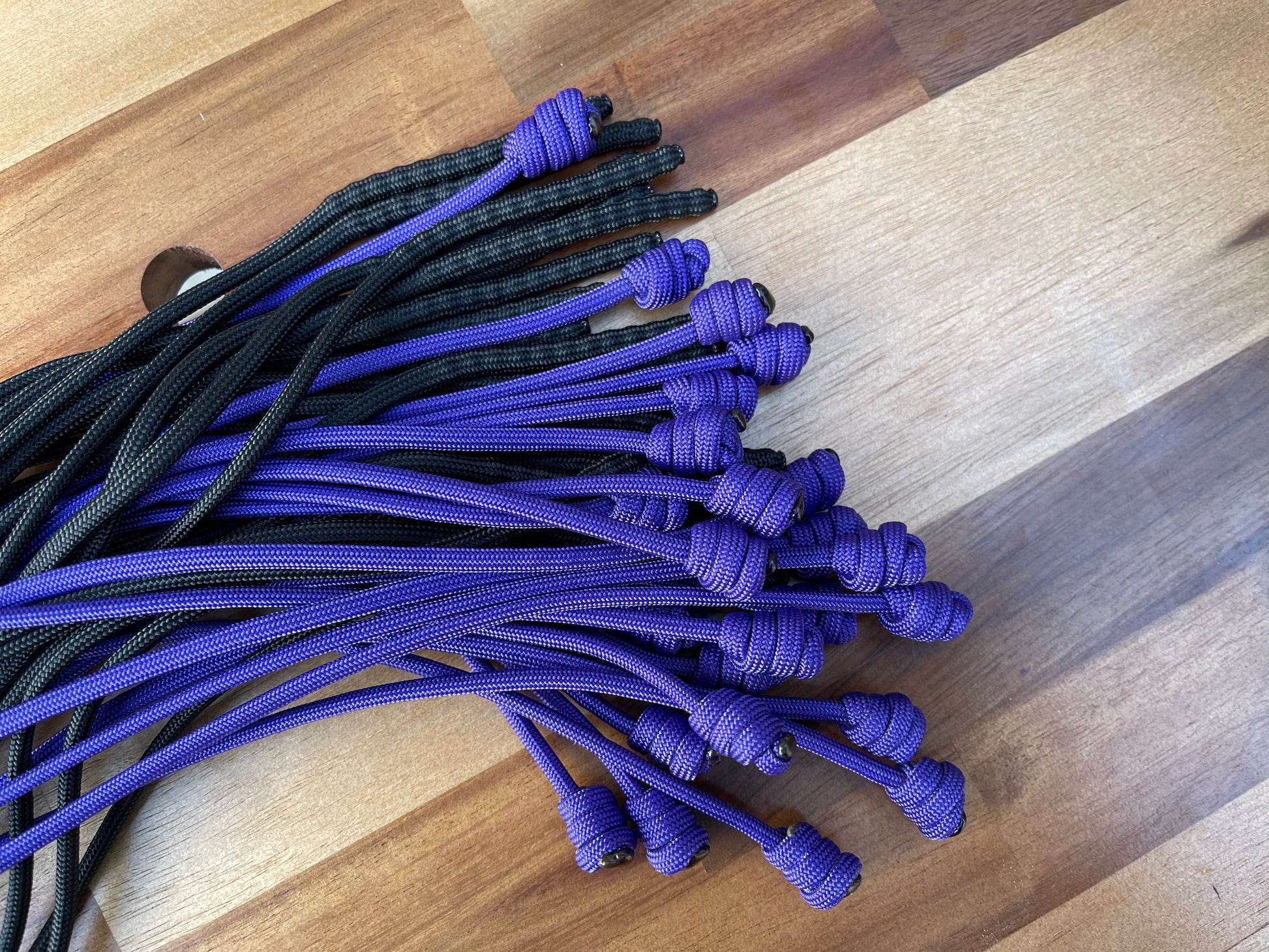 Weighted purple and black paracord flogger falls for BDSM and impact play