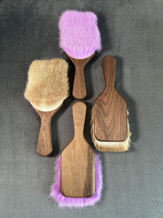 Four walnut Harebrush paddles on a grey background. Two purple and two natural in color