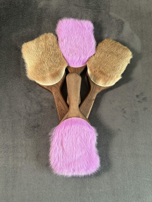 Four walnut Harebrush paddles on a grey background. Two purple and two natural in color